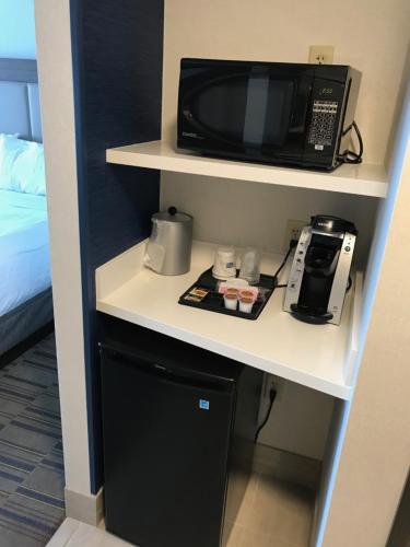 a microwave sitting on a shelf in a hotel room at Holiday Inn Express & Suites - Pittsburgh - Monroeville by IHG in Monroeville