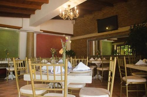 a dining room with tables and chairs and a chandelier at Porto Bello Hotel Boutique in Puerto Colombia