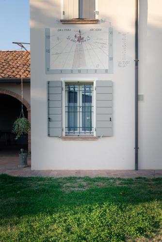 a clock on the side of a white building at B&B Arcadia in Gualtieri