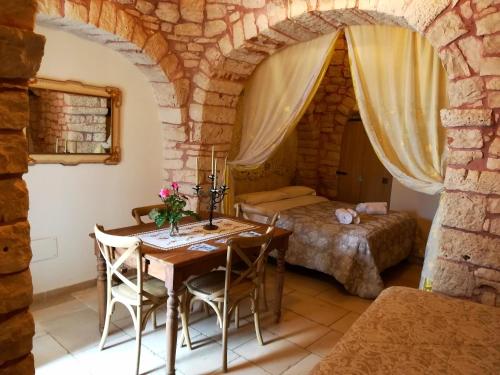 a bedroom with a table and a bed in a room at Trulli Resort Dimore Storiche in Alberobello
