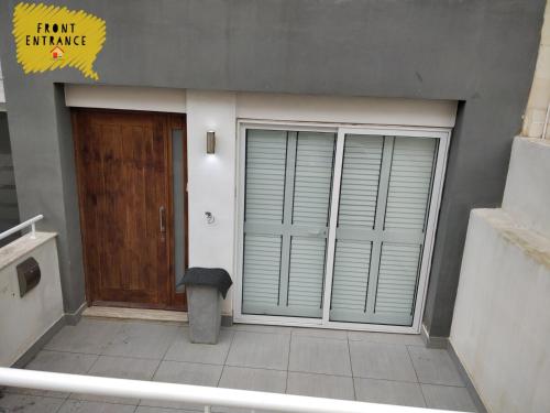 a building with a door and a trashcan in front of it at Modern Luxe Marsaskala Maisonette in Marsaskala