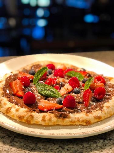 a pizza sitting on a plate on a table at Hotel Mission De Oro in Santa Nella Village