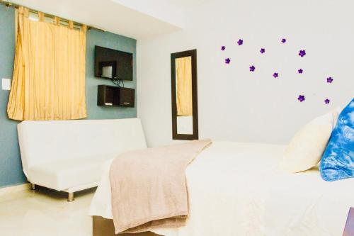 a bedroom with a white bed and a white chair at CondoHotel 5th Avenue Std Double Studio in Playa del Carmen