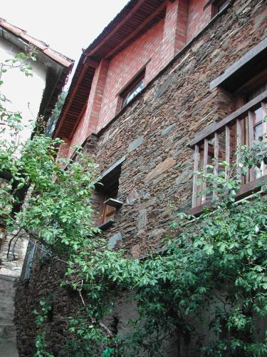 a brick building with a window and a tree at Casa Rural Valle del Arrago in Robledillo de Gata