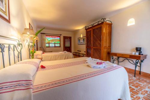 a hotel room with two beds and a window at Hacienda Uxmal Plantation & Museum in Uxmal