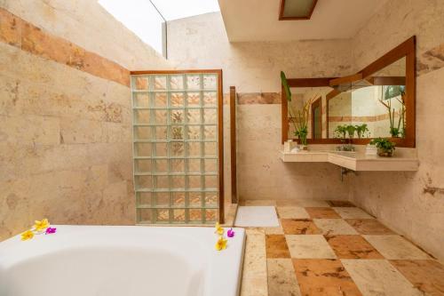 a bathroom with a tub and a mirror at Hacienda Uxmal Plantation & Museum in Uxmal