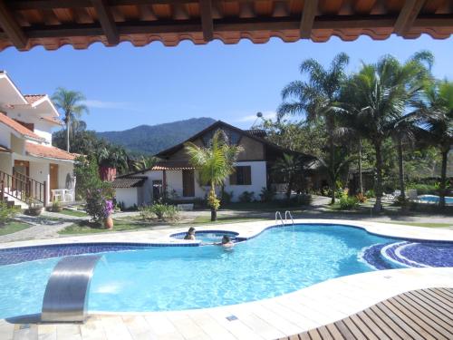 two people in a swimming pool in a house at Recanto da Praia in Paraty