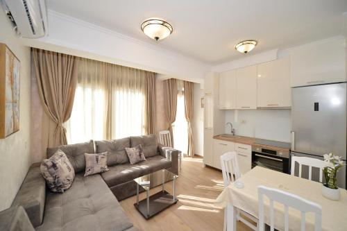 ein Wohnzimmer mit einem Sofa und einem Tisch sowie eine Küche in der Unterkunft Langust - free parking in Sveti Stefan