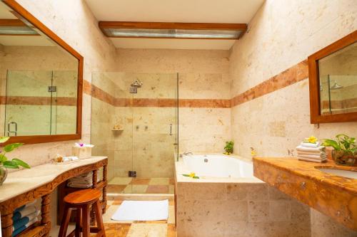a bathroom with a tub and a shower and a sink at Hacienda Uxmal Plantation & Museum in Uxmal