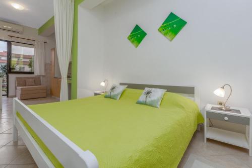 - une chambre avec un grand lit vert dans l'établissement Studio Apartments Romina, à Vrsar