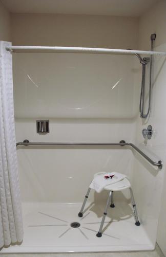 a white shower with a stool in a bathroom at Homestead Inn and Suites in Hardin