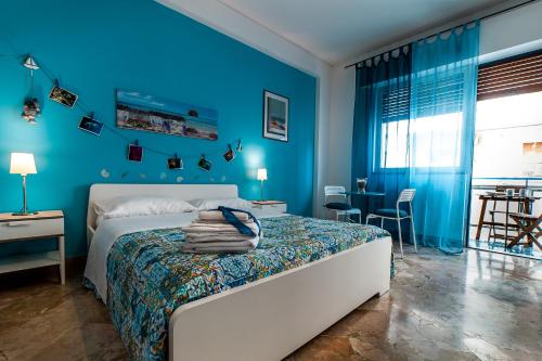 ein blaues Schlafzimmer mit einem Bett und einem Tisch in der Unterkunft Le stanze di Irma in Palermo