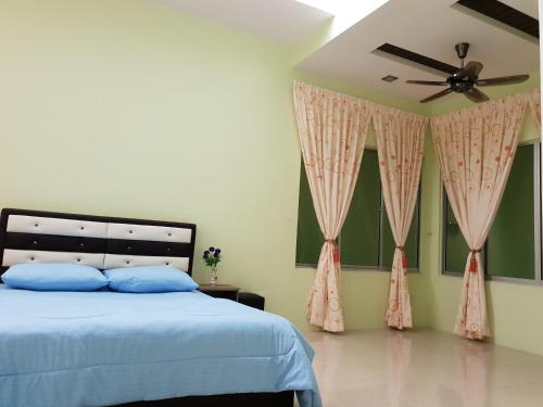 a bedroom with a bed and a ceiling fan at Islamic Homestay Sungai Petani in Sungai Petani