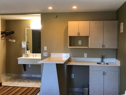 a kitchen with white cabinets and a sink at Super 8 by Wyndham S Jordan/Sandy/Slc Area in South Jordan