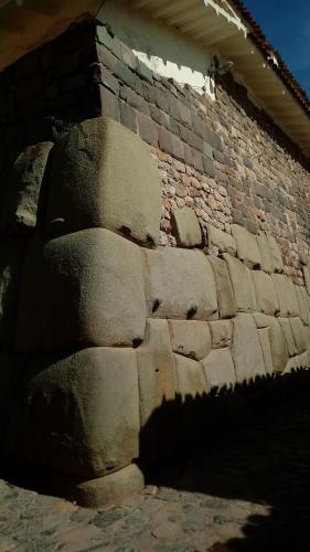 a brick wall with a shadow on the side of a building at Casa De Mama Cusco - The Treehouse in Cusco
