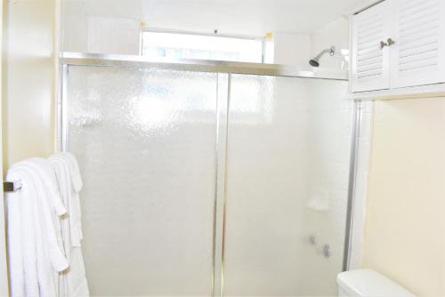 W łazience znajduje się prysznic ze szklanymi drzwiami. w obiekcie Golden Sand Oceanfront w mieście Hollywood