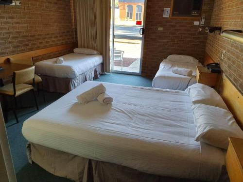a hotel room with two beds and a television at Corowa Golf Club Motel in Corowa
