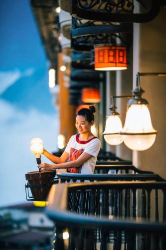 a woman sitting at a table with a lamp at Hotel de la Coupole - MGallery in Sa Pa