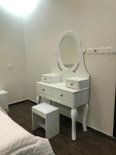 a white dressing table with a mirror and a bed at شاليه الماسة in Taif