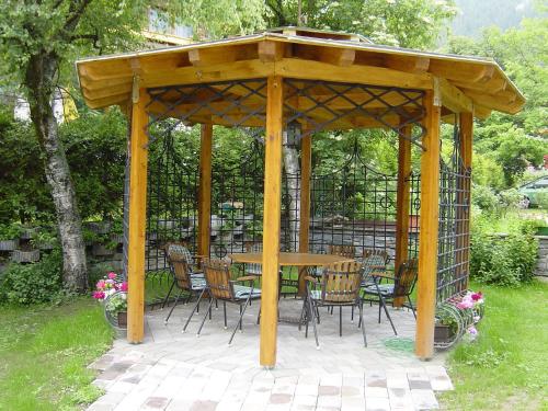 a wooden gazebo with a table and chairs at Frühstückshotel Margret in Maurach