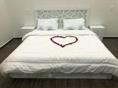 a white bed with a heart on it at شاليه الماسة in Taif