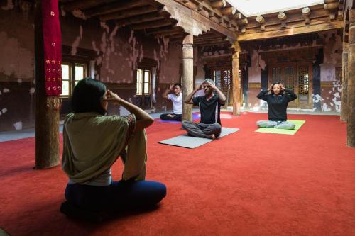 un grupo de personas sentadas en una habitación haciendo yoga en Nimmu House Ladakh, en Nimu
