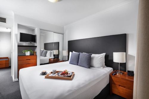 a hotel room with a bed and a dresser at The Sebel Brisbane in Brisbane