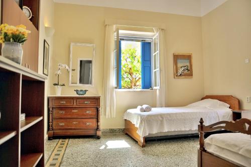 a bedroom with a bed and a dresser and a window at Elena's Guest House in Aegina Town