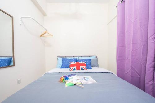 a bedroom with a bed with a purple curtain and books at SetiaWalk {BIG GROUP}12Pax WIFI 2C'Park IOI SUNWAY SUBANG USJ in Puchong
