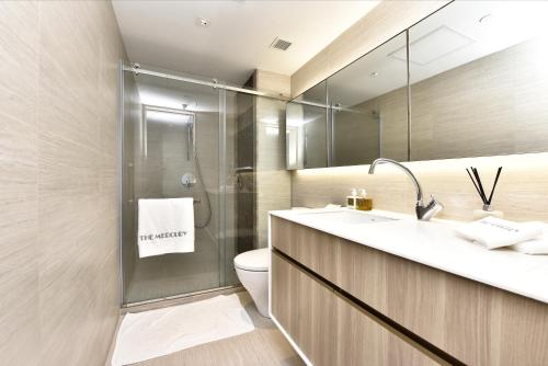 a bathroom with a shower and a toilet and a sink at The Mercury in Hong Kong
