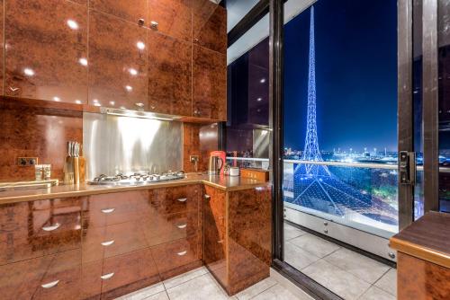 a kitchen with a view of the eiffel tower at Exclusive Stays - Gallery Penthouse in Melbourne