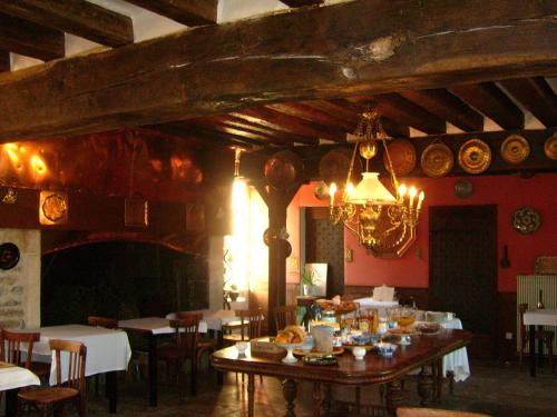 una sala da pranzo con tavolo, sedie e lampadario pendente di Château d'Island Vézelay a Pontaubert
