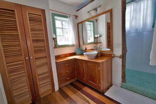 a bathroom with a sink and a mirror at Sea Dreams Hotel in Caye Caulker