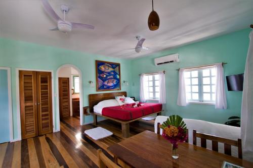 a bedroom with a bed and a table in a room at Sea Dreams Hotel in Caye Caulker