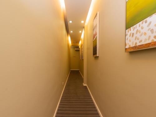 a long hallway with stairs and paintings on the walls at MIO BOUTIQUE Hotel in Melaka