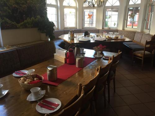 a dining room with a table and chairs in a restaurant at Weinschlößchen im Weingut Roos in Ilbesheim