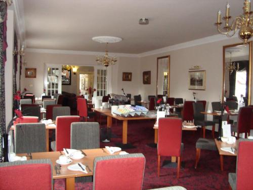 un comedor con mesas y sillas en un restaurante en The Minster Hotel, en York