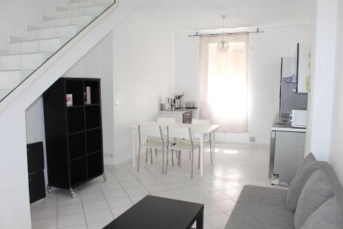 ein weißes Wohnzimmer mit einem Tisch und einer Küche in der Unterkunft Residence Enzo Paradise in La Seyne-sur-Mer