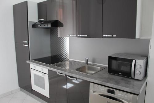 una pequeña cocina con fregadero y microondas en Residence Enzo Paradise, en La Seyne-sur-Mer