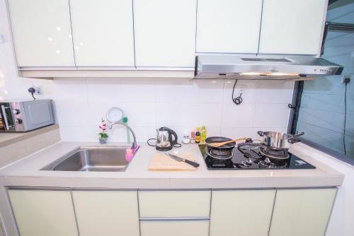 a kitchen with a sink and a stove top oven at SetiaWalk {BIG GROUP}12Pax WIFI 2C'Park IOI SUNWAY SUBANG USJ in Puchong