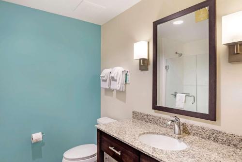 ein Badezimmer mit einem Waschbecken, einem WC und einem Spiegel in der Unterkunft Sleep Inn Lancaster Dallas South in Lancaster