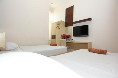 a room with two beds and a flat screen tv at Ranez Inn in Tegal