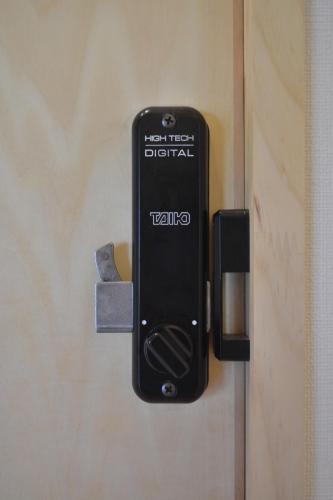 a black cell phone is attached to a door at BED N CHILL Shippoya 七宝屋 in Mitoyo