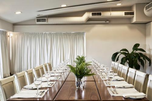 a long table in a room with chairs and glasses at Civitel Olympic in Athens