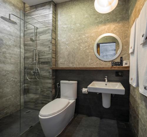 a bathroom with a toilet and a sink at Wheeler Bed &Bike in Bangsaen