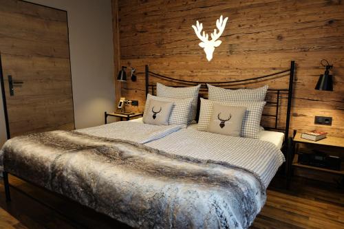 a bedroom with a bed with a wooden wall at Montara Suites Bodenmais in Bodenmais