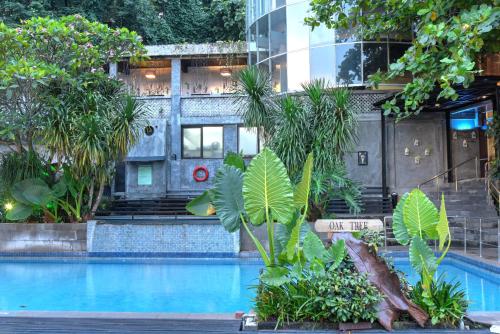 a hotel with a swimming pool in front of a building at Oak Tree Emerald Hotel & Coventions Semarang in Semarang