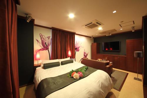 a bedroom with a large bed with flowers on it at Watergate Funabashi in Funabashi