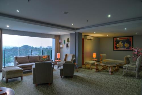 a living room with a couch and chairs at Oak Tree Emerald Semarang Managed by The Ascott Limited in Semarang
