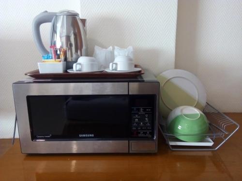 a microwave on a table with a tea pot on top at Seaview Sriracha Hotel in Si Racha